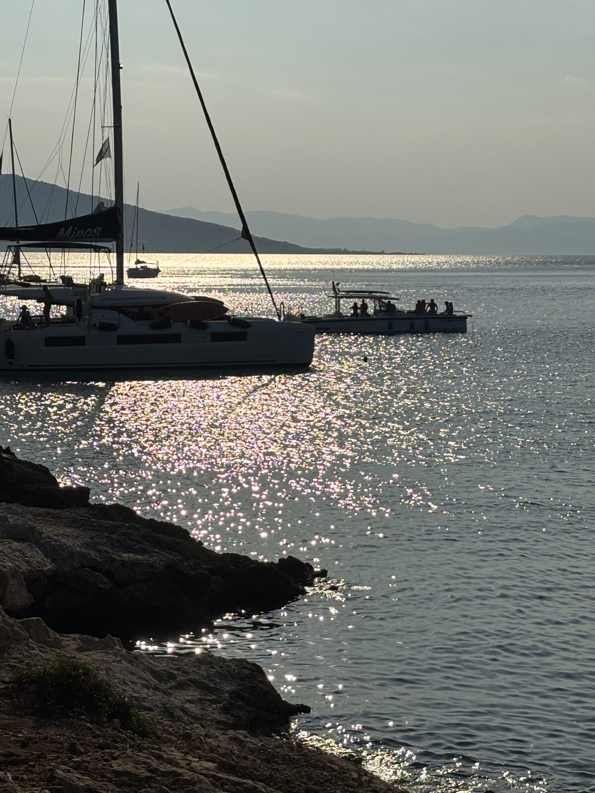 A yacht against the light on the water at dusk